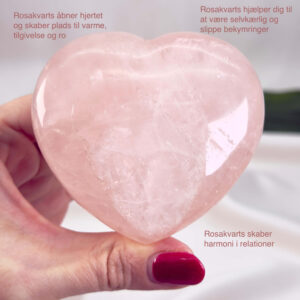 Rosakvarts Hjerte Krystal Sten på hvid baggrund i hånd med tags