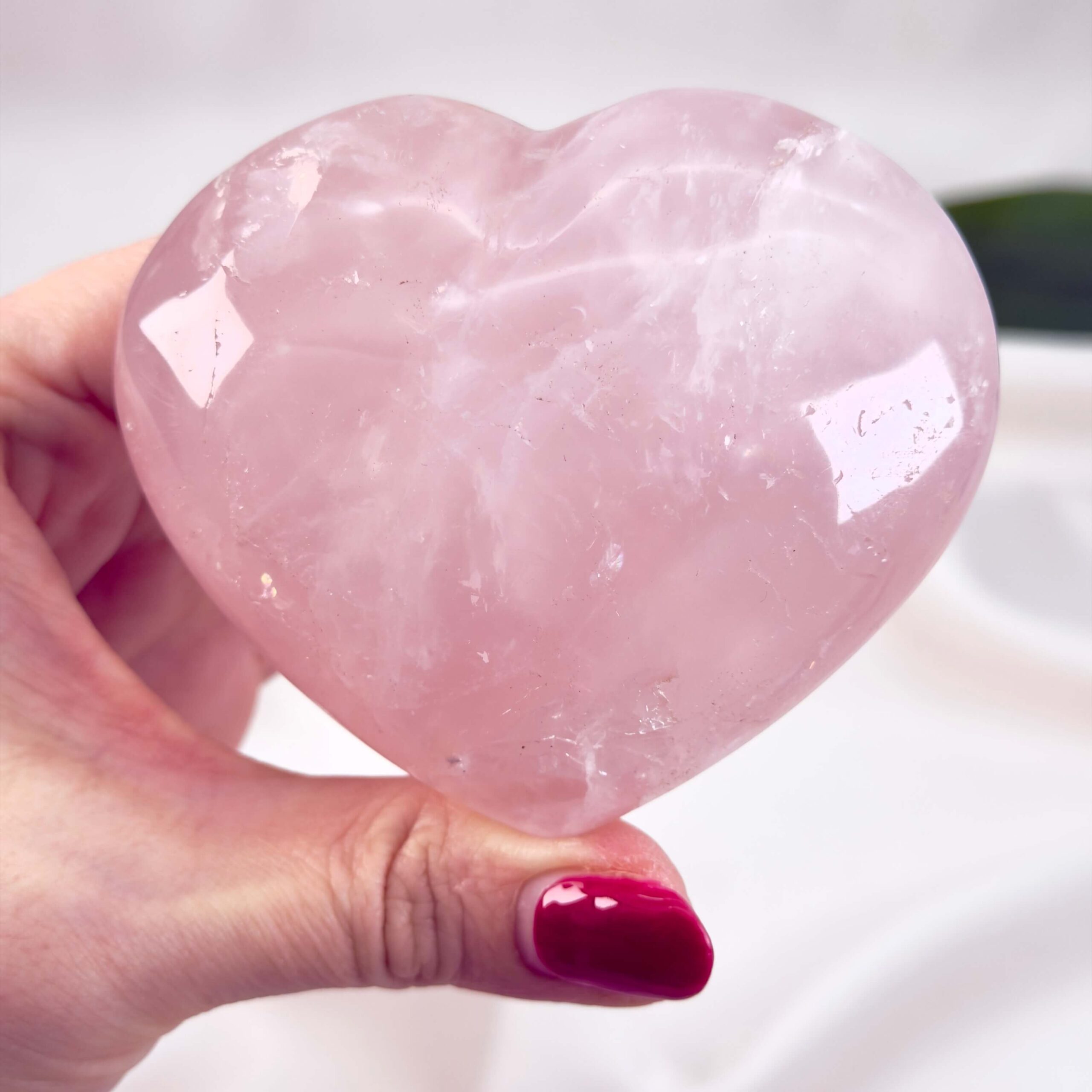 Rosakvarts Hjerte Krystal Sten på hvid baggrund i hånd