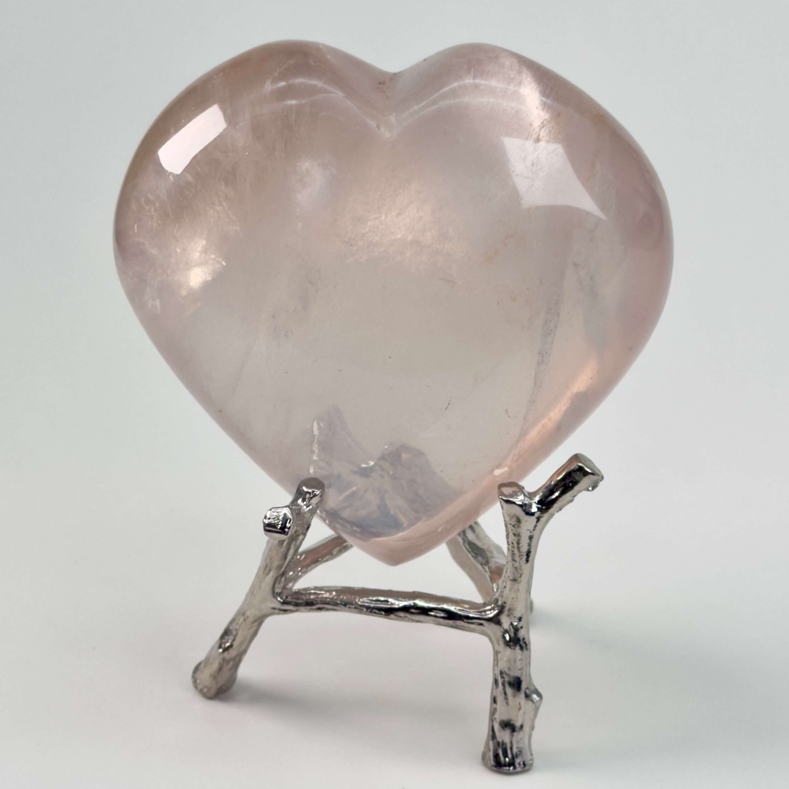 Rosakvarts Hjerte Krystal Sten på hvid baggrund på holder