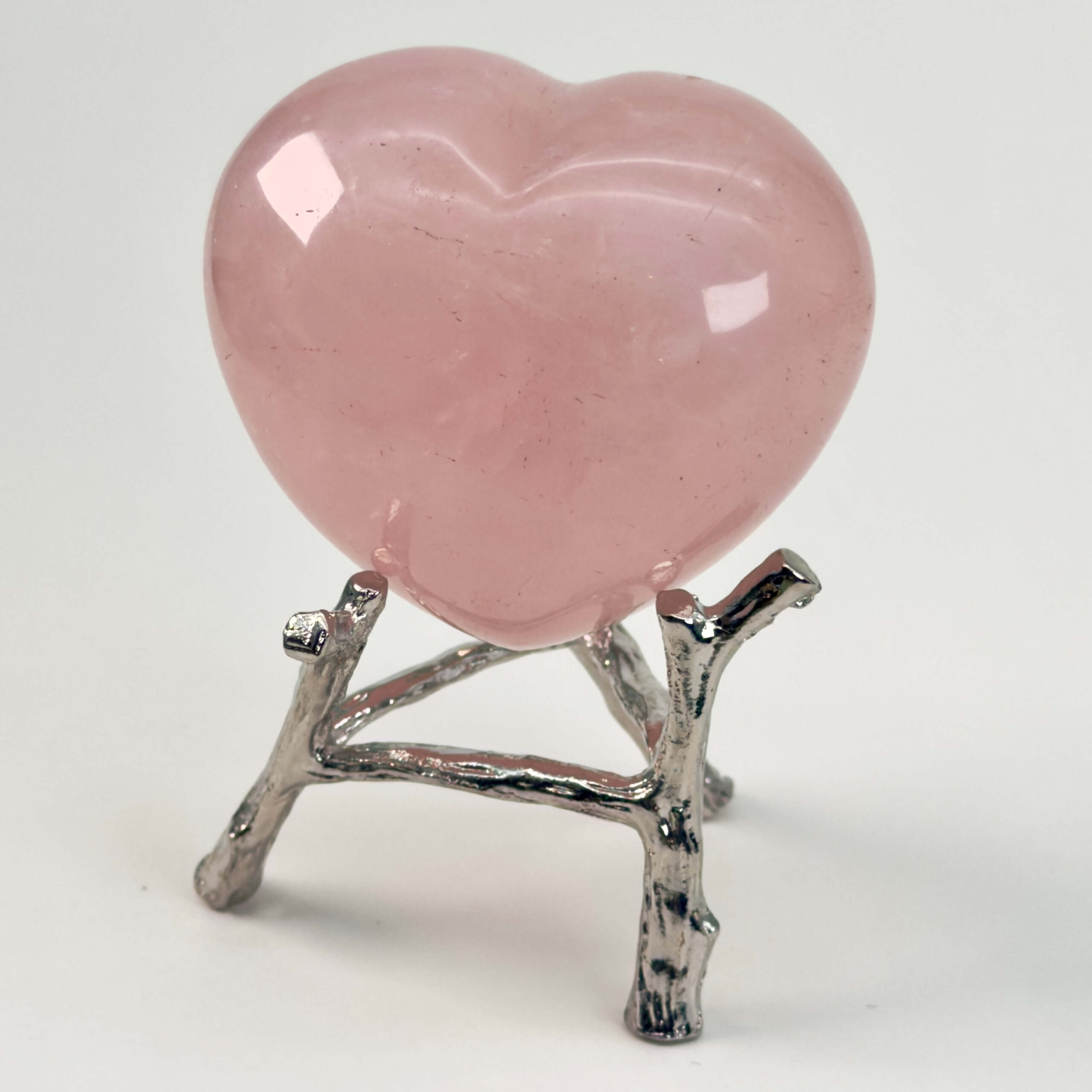 Rosakvarts Hjerte Krystal Sten på hvid baggrund på holder
