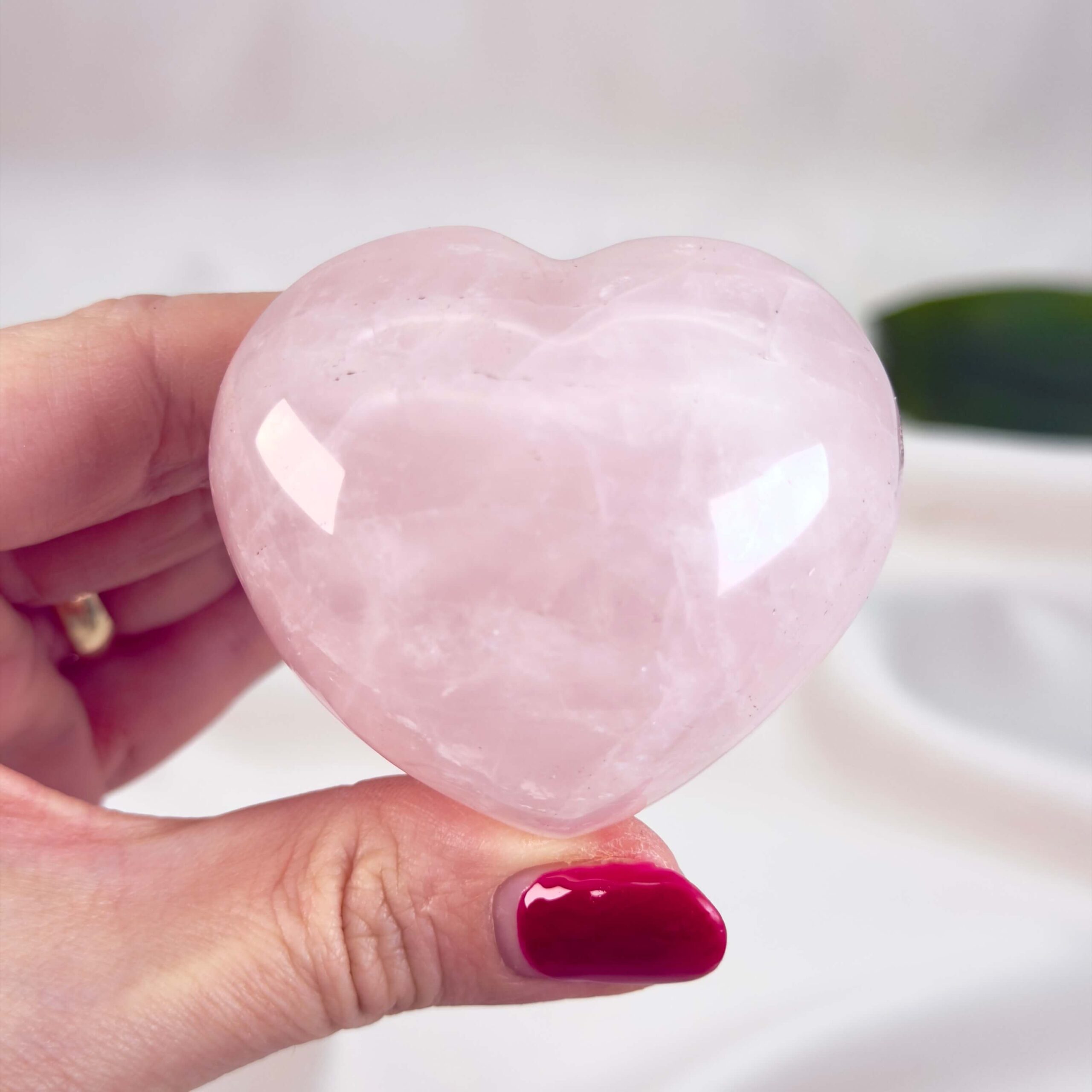 Rosakvarts Hjerte Krystal Sten på hvid baggrund i hånd