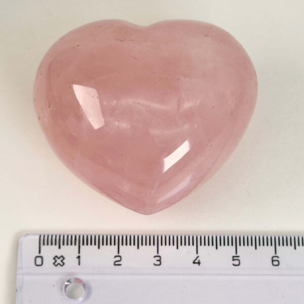 Rosakvarts Hjerte Krystal Sten på hvid baggrund med lineal