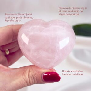 Rosakvarts Hjerte Krystal Sten på hvid baggrund i hånd med tags