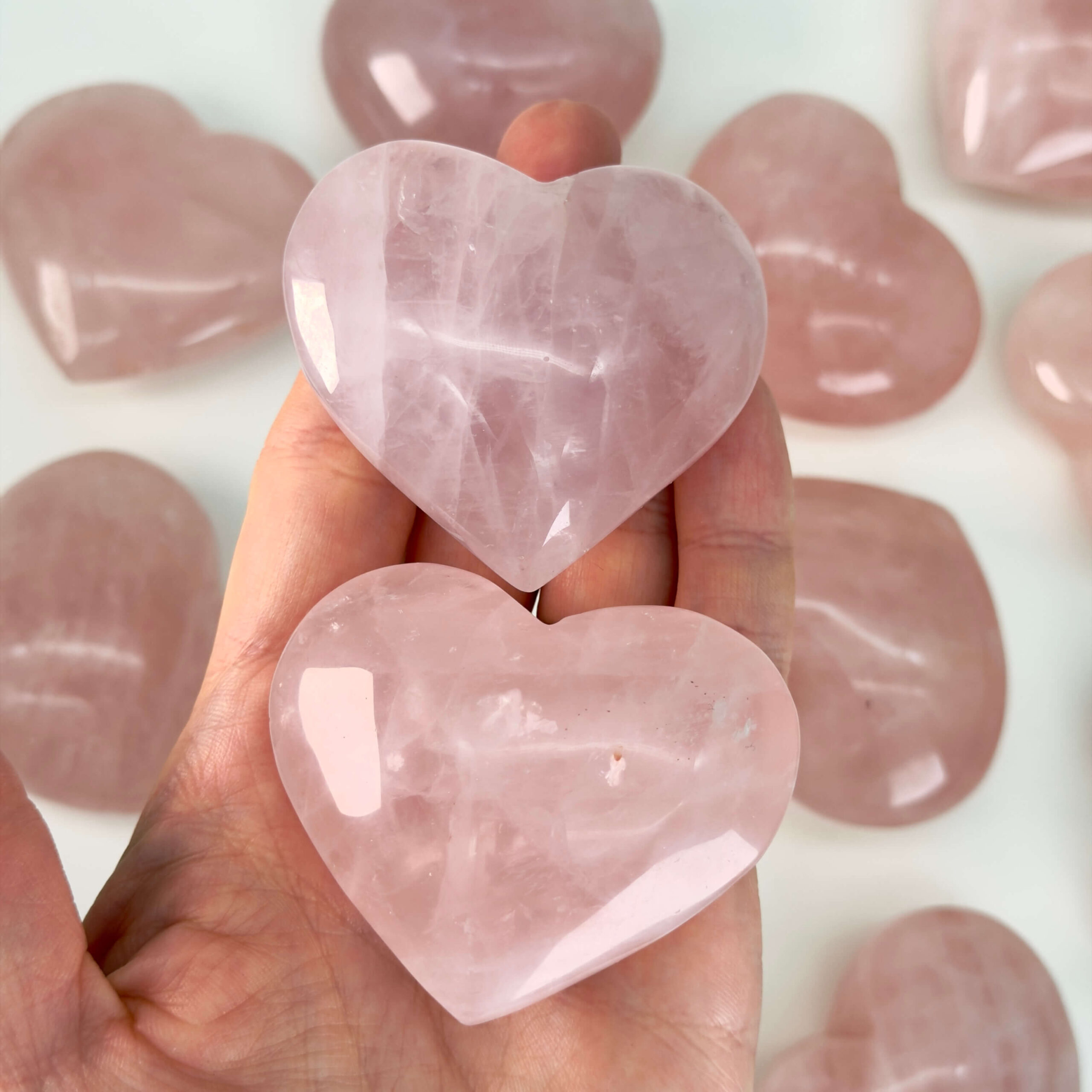 Rosakvarts Hjerte Krystal Sten på hvid baggrund i hånd