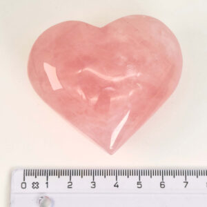 Rosakvarts Hjerte Krystal Sten på hvid baggrund med lineal