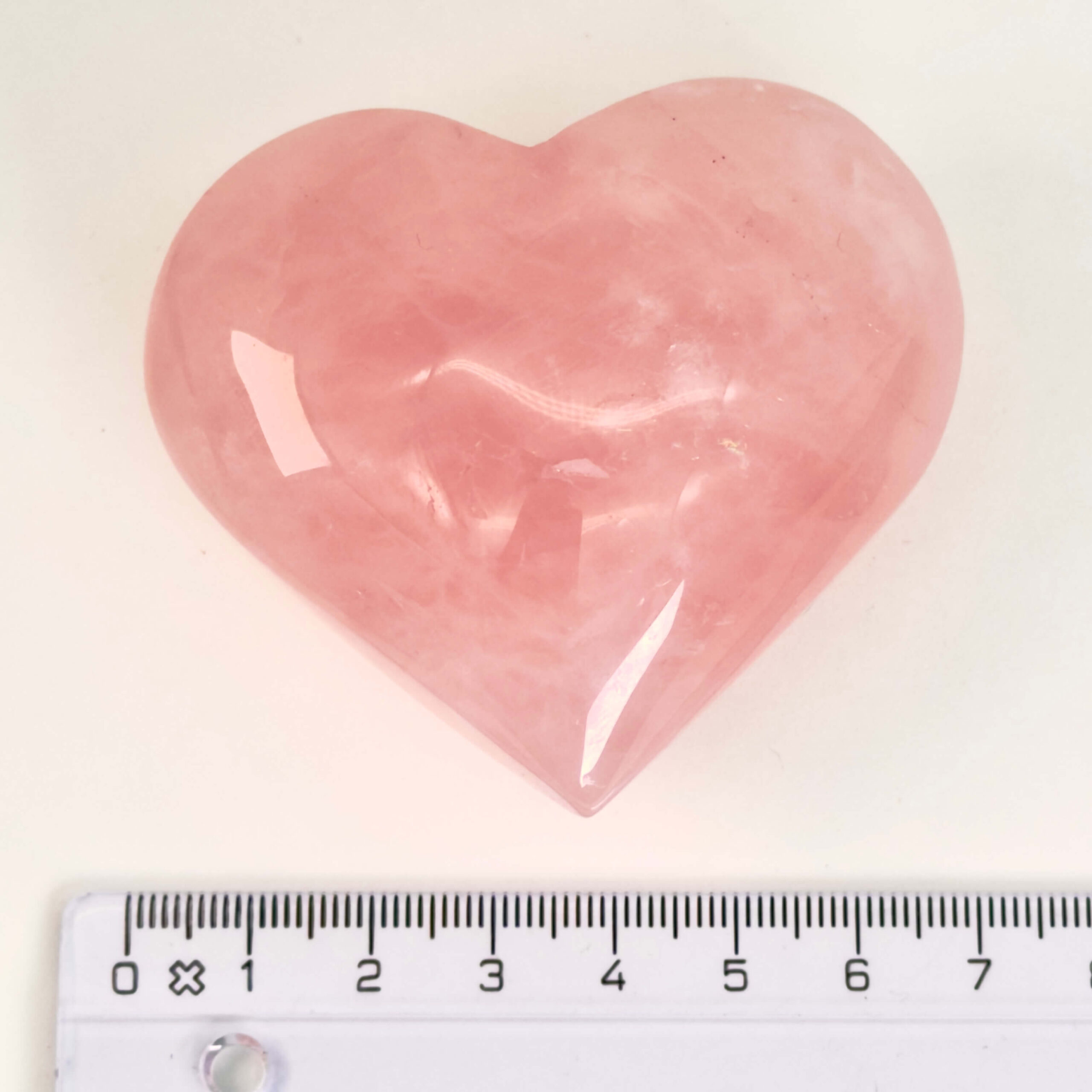 Rosakvarts Hjerte Krystal Sten på hvid baggrund med lineal