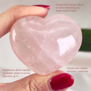 Rosakvarts Hjerte Krystal Sten på hvid baggrund i hånd med tags