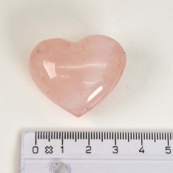 Rosakvarts Hjerte Krystal Sten på hvid baggrund med lineal