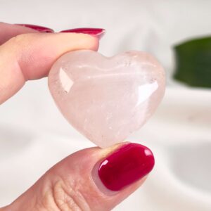 Rosakvarts Hjerte Krystal Sten på hvid baggrund i hånd