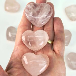 Rosakvarts Hjerte Krystal Sten på hvid baggrund i hånd