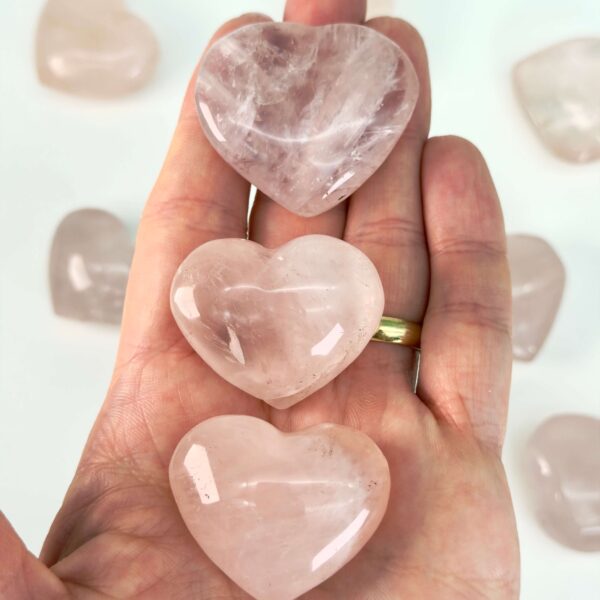 Rosakvarts Hjerte Krystal Sten på hvid baggrund i hånd