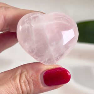 Rosakvarts Hjerte Krystal Sten på hvid baggrund i hånd