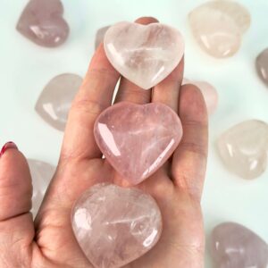 Rosakvarts Hjerte Krystal Sten på hvid baggrund i hånd