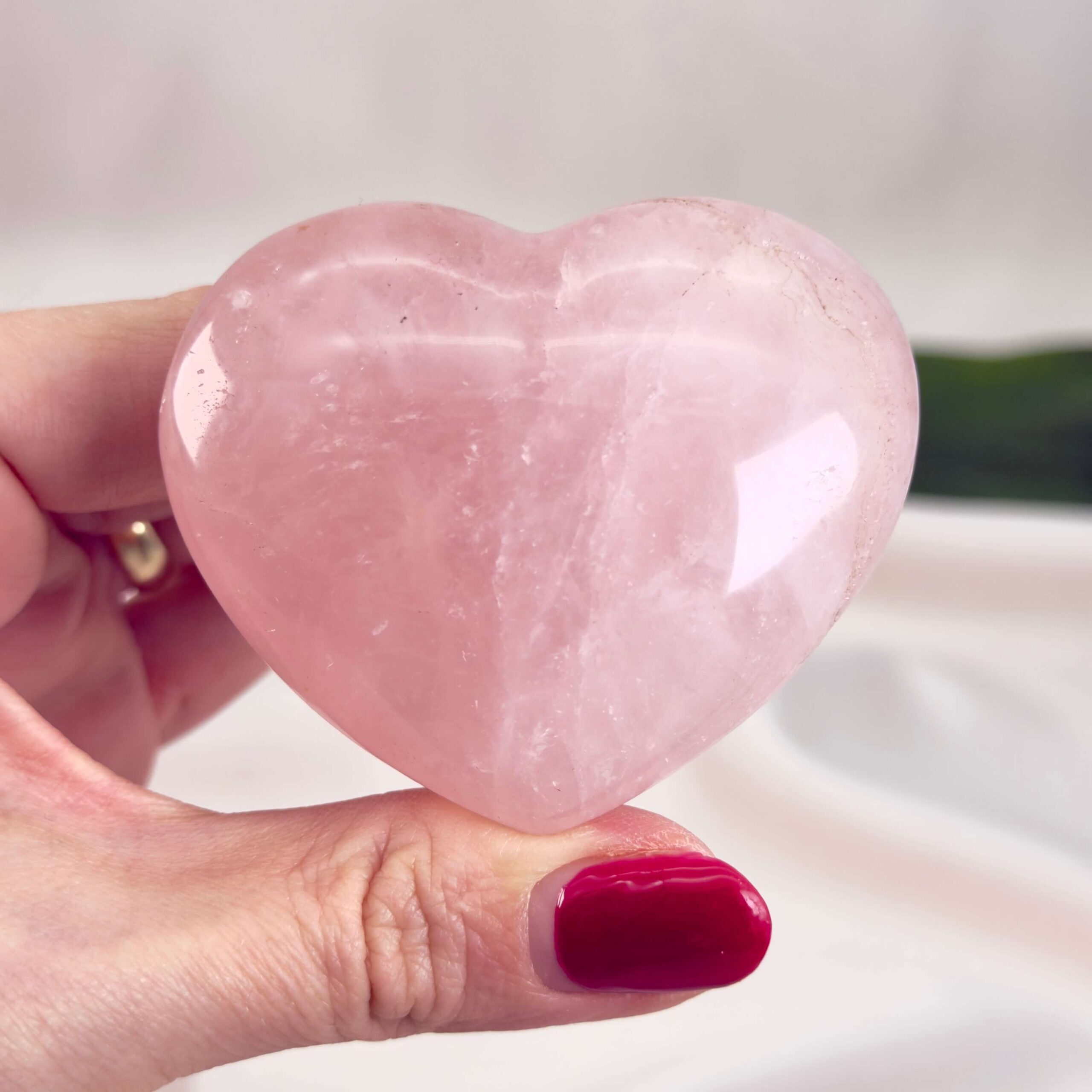 Rosakvarts Hjerte Krystal Sten på hvid baggrund i hånd