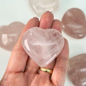 Rosakvarts Hjerte Krystal Sten på hvid baggrund i hånd