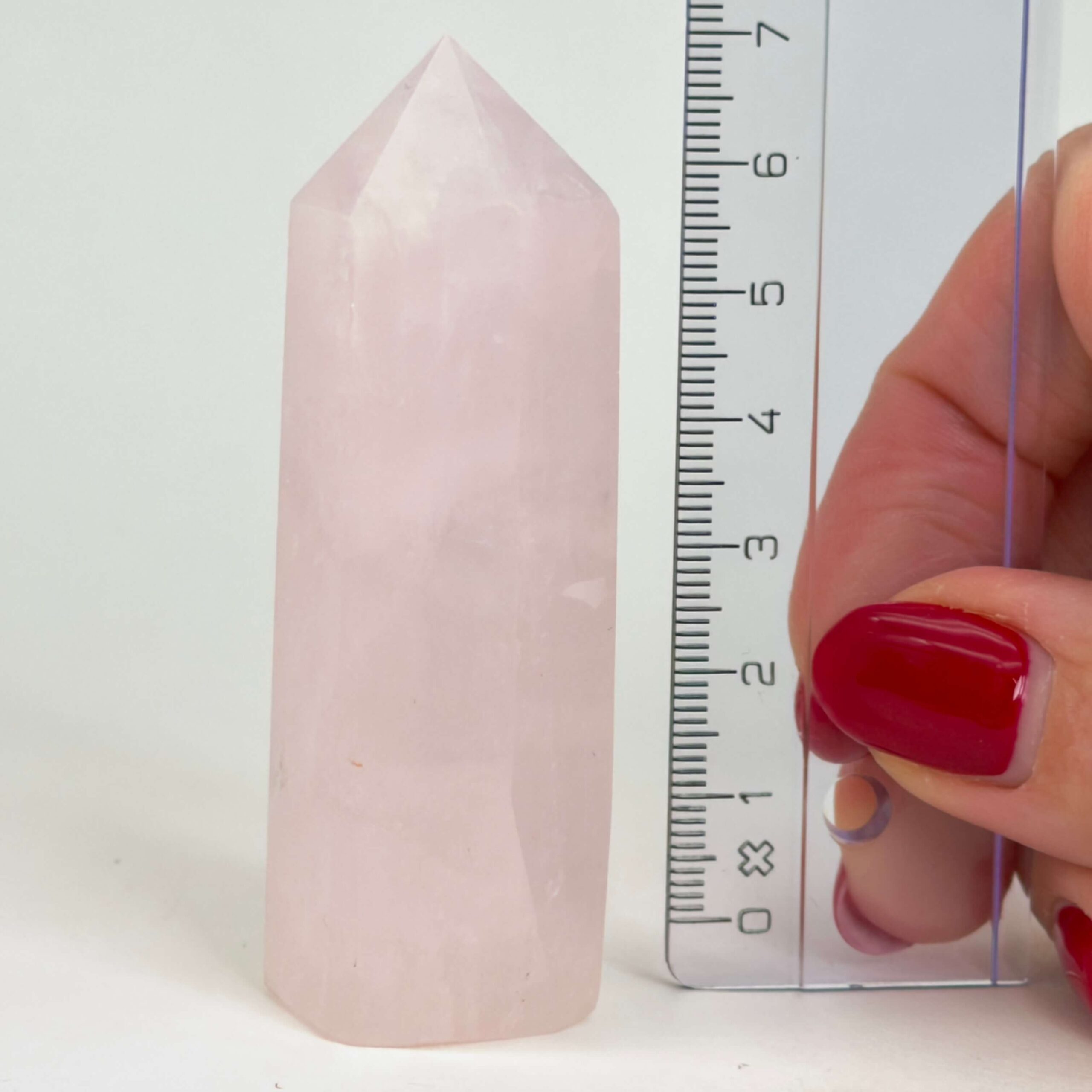 Rosakvarts Tårn krystal sten med lineal på hvid baggrund