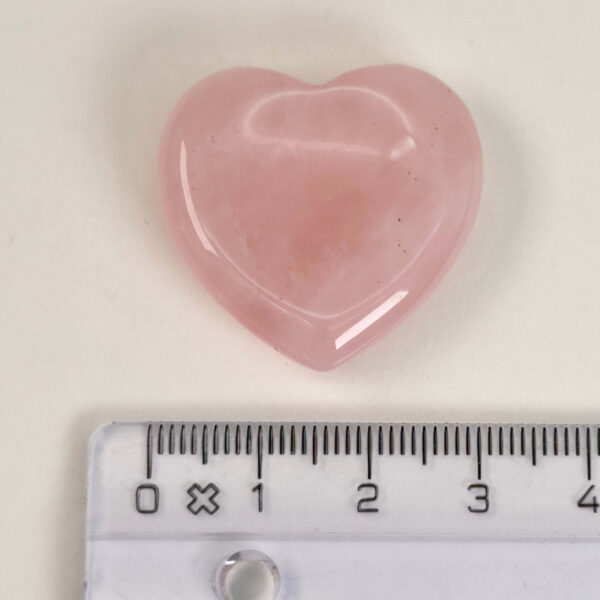 Rosakvarts Hjerte Krystal Sten på hvid baggrund med lineal
