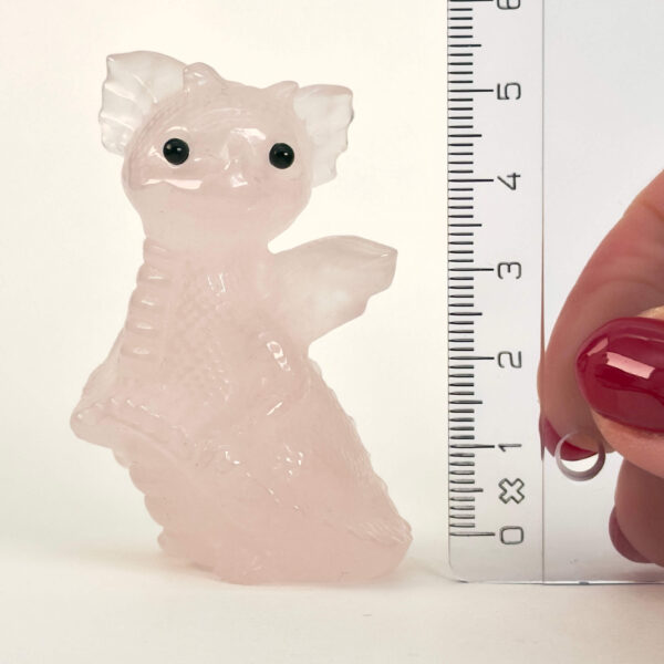 Rosakvarts Babydrage Krystal sten med lineal på hvid baggrund