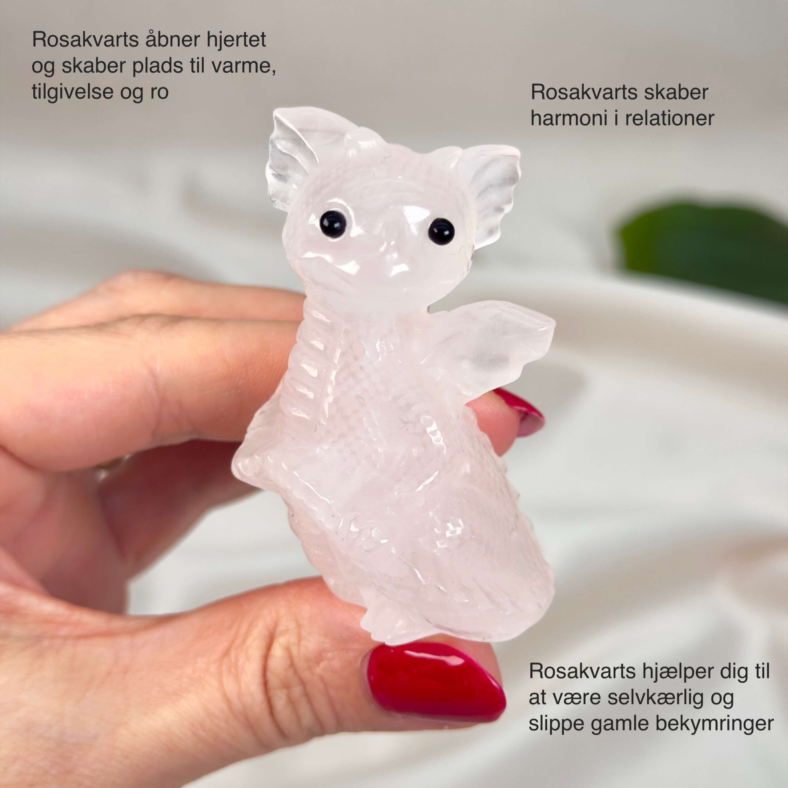 Rosakvarts Babydrage Krystal sten i hånd på hvid baggrund med tags