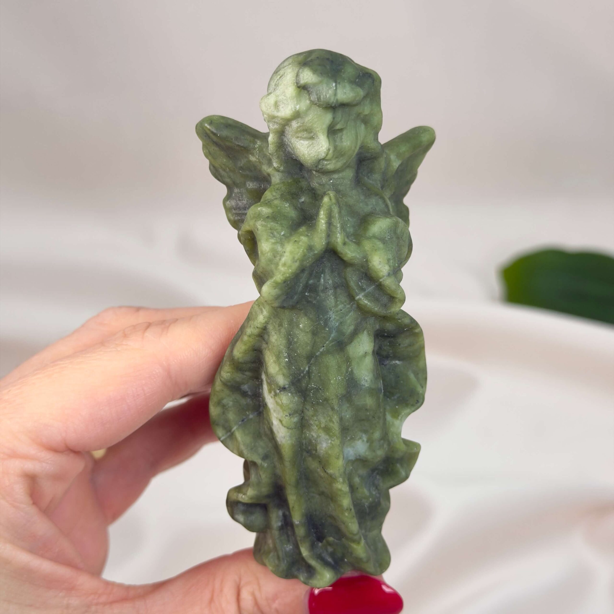 Serpentin Engel krystal sten i hånd på hvid baggrund