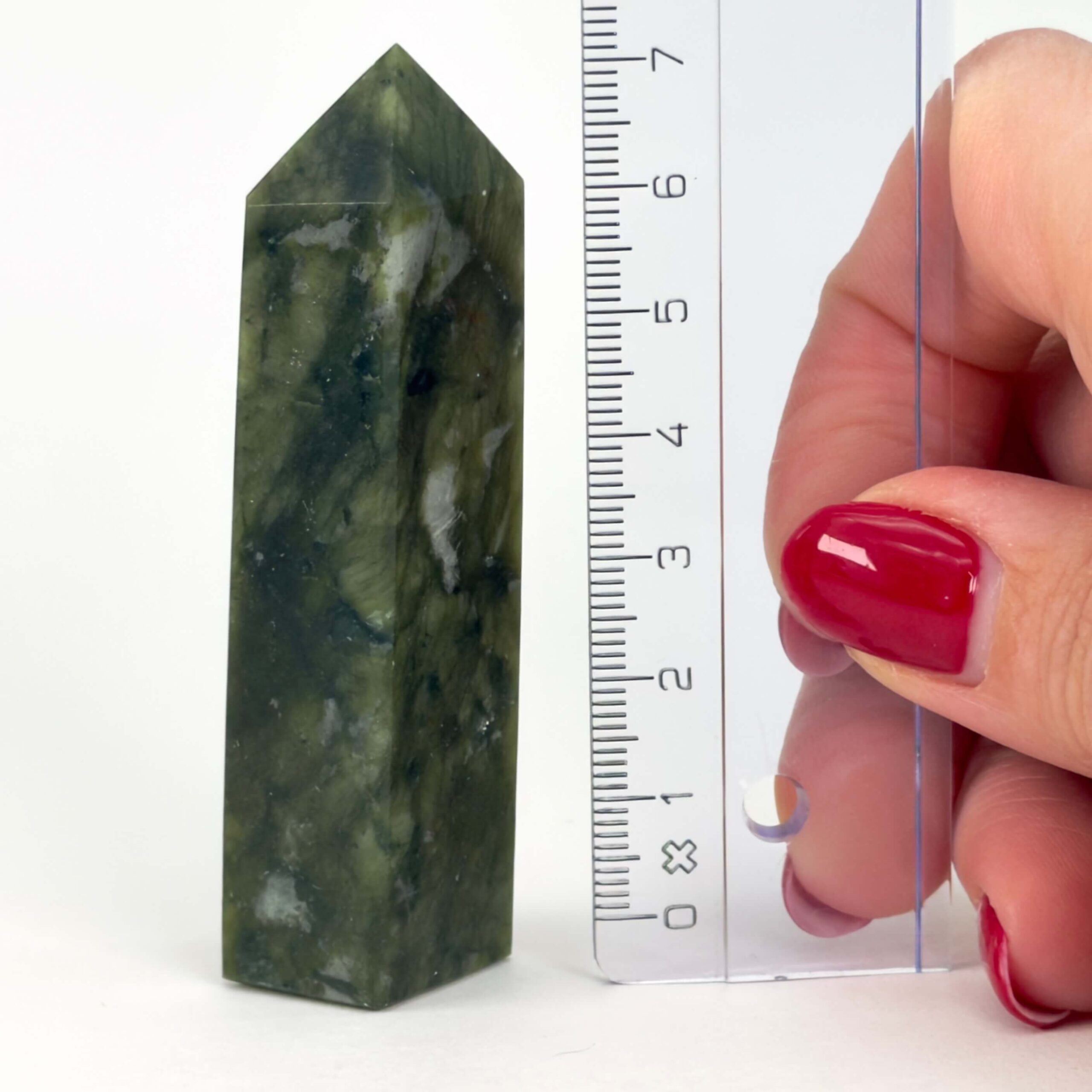 Serpentin Tårn krystal sten med lineal på hvid baggrund