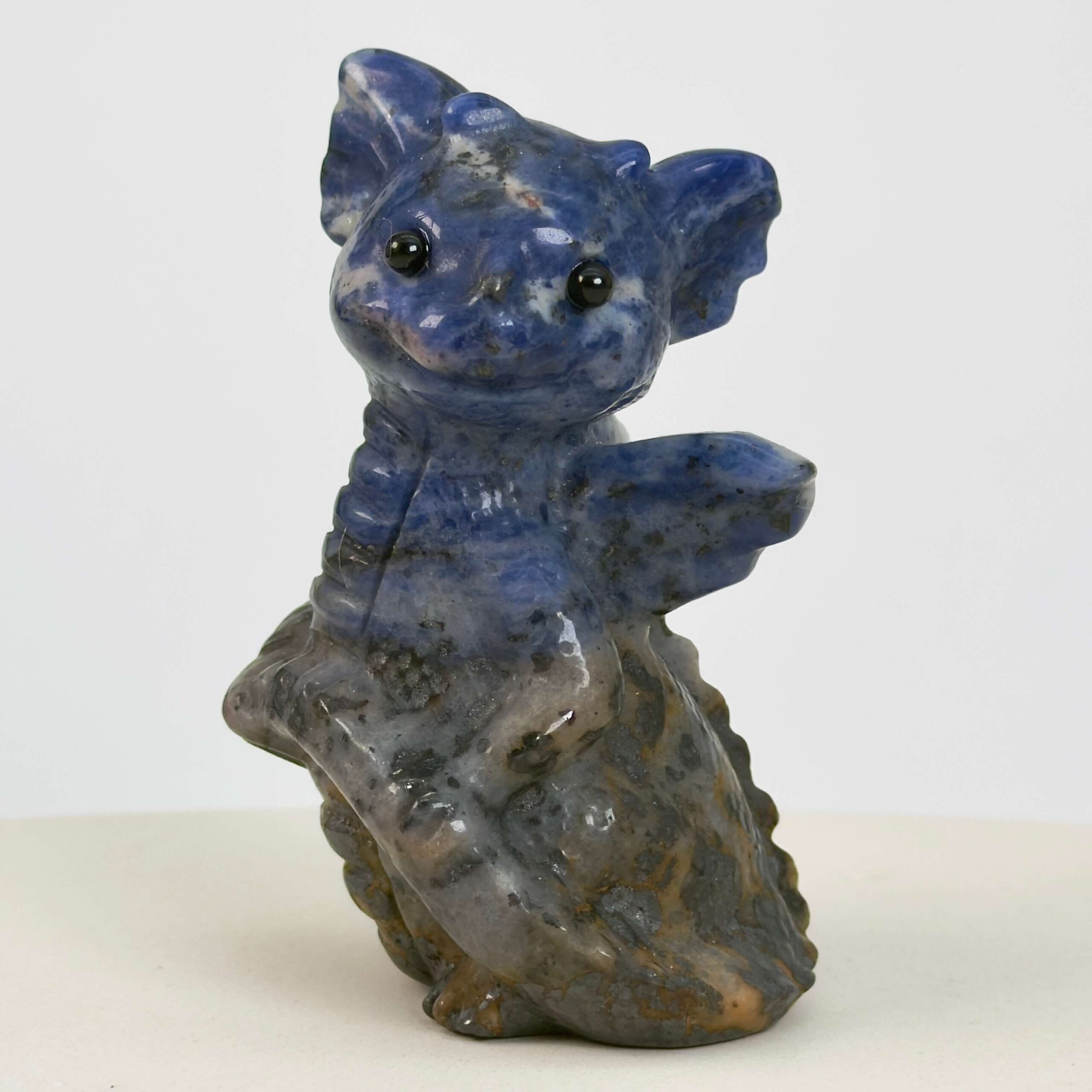 Sodalit Babydrage Krystal sten på hvid baggrund