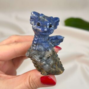 Sodalit Babydrage Krystal sten i hånd på hvid baggrund