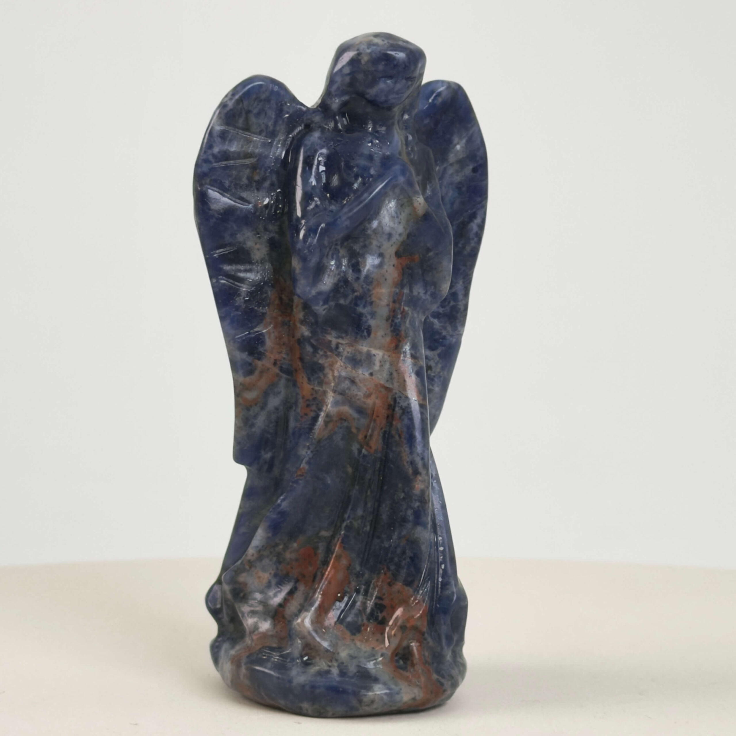 Sodalit Engel krystal sten i hånd på hvid baggrund