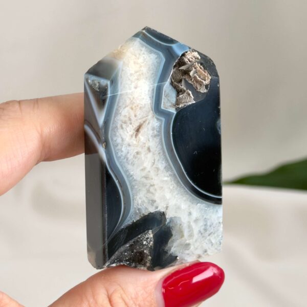 Sort Agat Tårn krystal sten i hånd på hvid baggrund