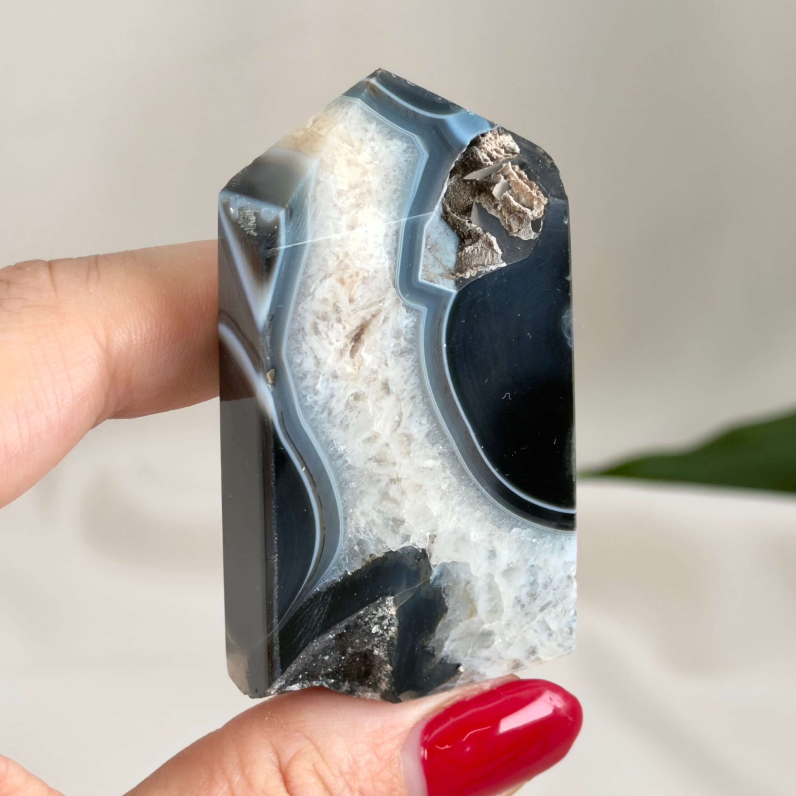 Sort Agat Tårn krystal sten i hånd på hvid baggrund