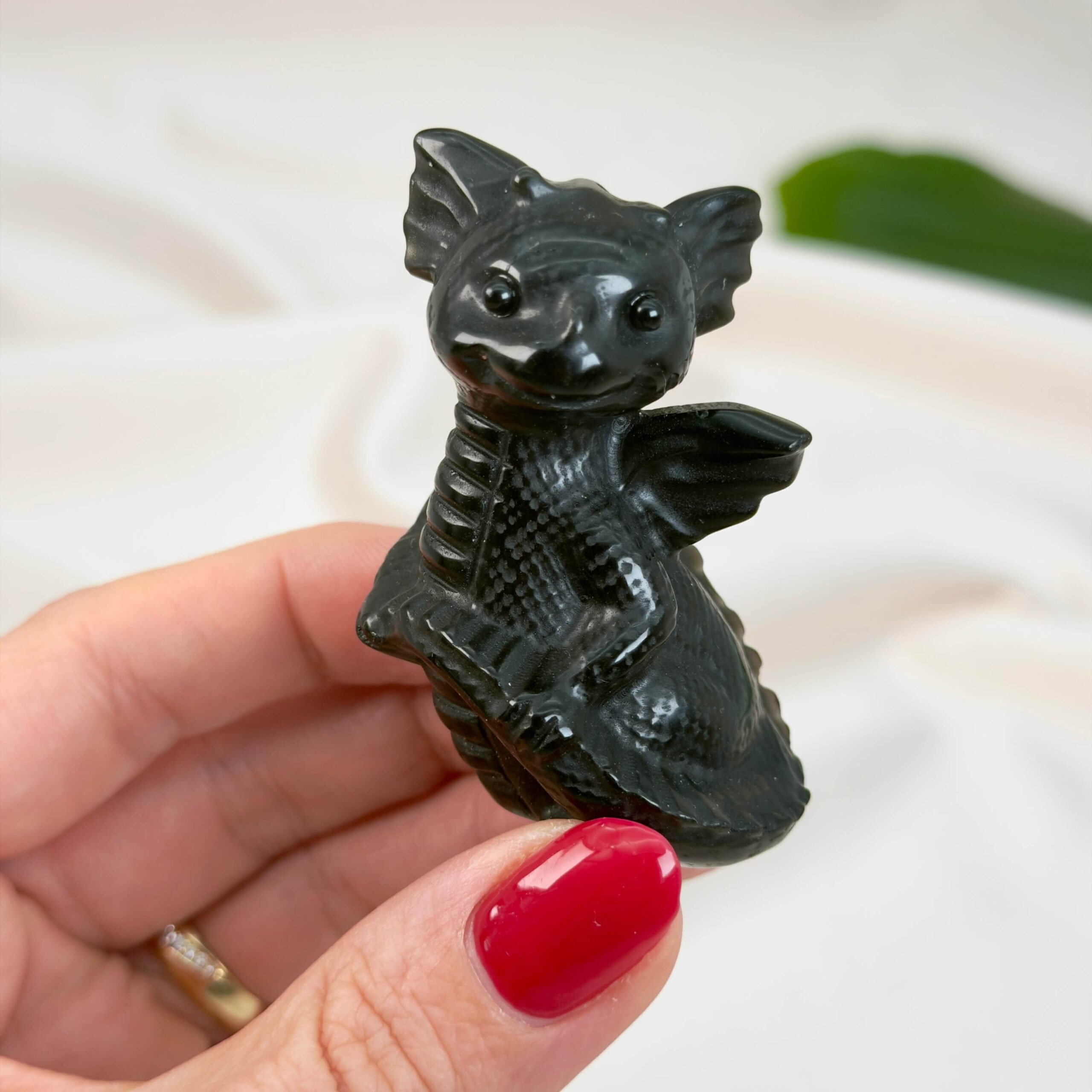 Sort Obsidian Babydrage Krystal sten i hånd på hvid baggrund