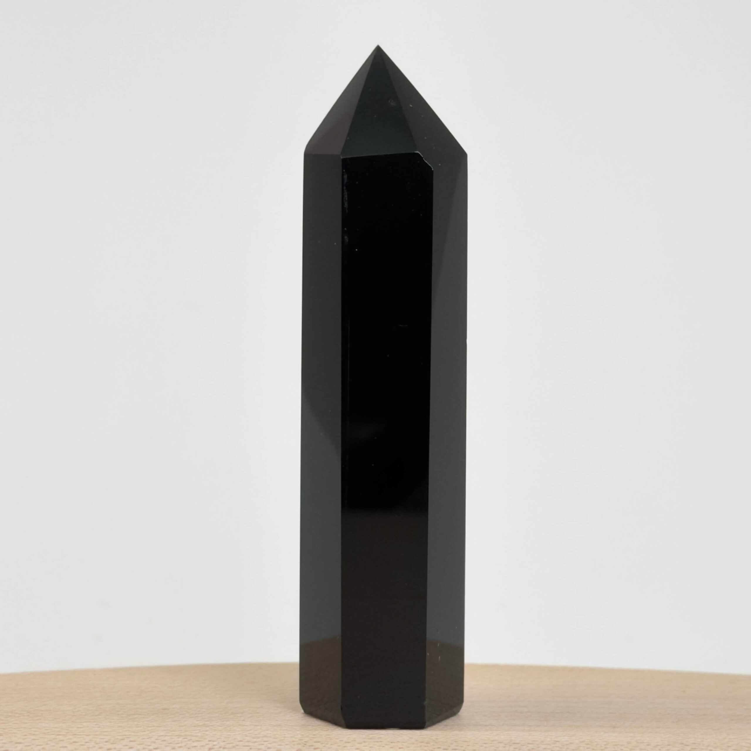 Sort Obsidian Tårn Krystal Sten på hvid baggrund