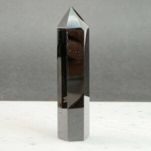 Sort Obsidian Tårn Krystal Sten på sort hvid baggrund