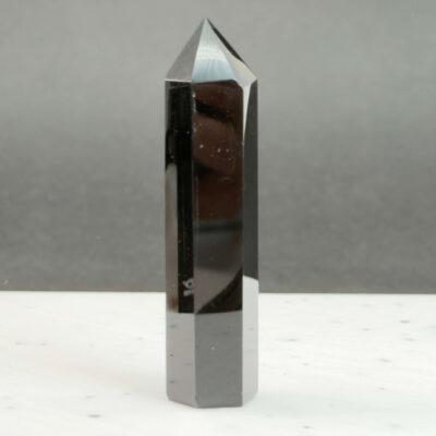 Sort Obsidian Tårn Krystal Sten på sort hvid baggrund