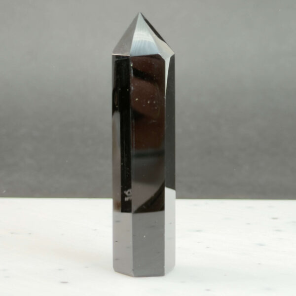 Sort Obsidian Tårn Krystal Sten på sort hvid baggrund