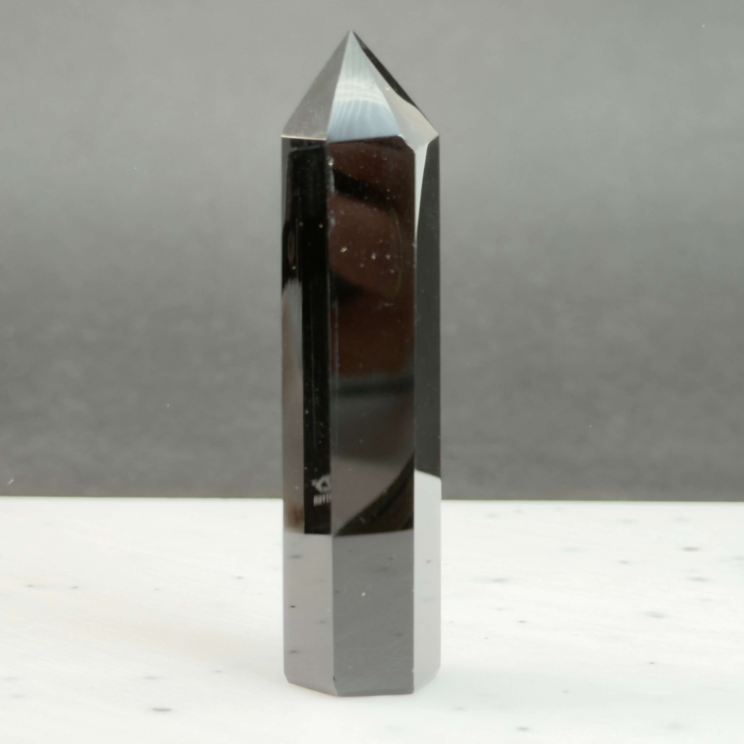 Sort Obsidian Tårn Krystal Sten på sort hvid baggrund