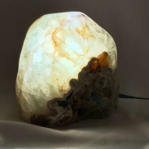 Agat lampe med naturlige mønstre og farvespil, der udsender et varmt og roligt lys i rummet.