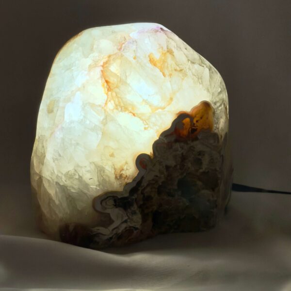 Agat lampe med naturlige mønstre og farvespil, der udsender et varmt og roligt lys i rummet.