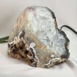Agat lampe med naturlige mønstre og farvespil, der udsender et varmt og roligt lys i rummet.