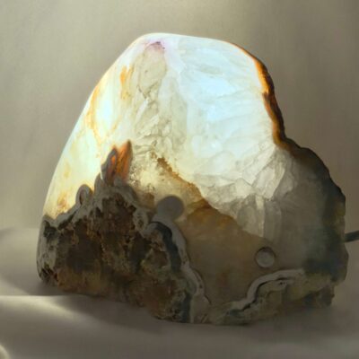 Agat lampe med naturlige mønstre og farvespil, der udsender et varmt og roligt lys i rummet.