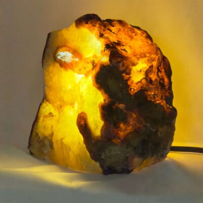 Agat lampe med naturlige mønstre og farvespil, der udsender et varmt og roligt lys i rummet.