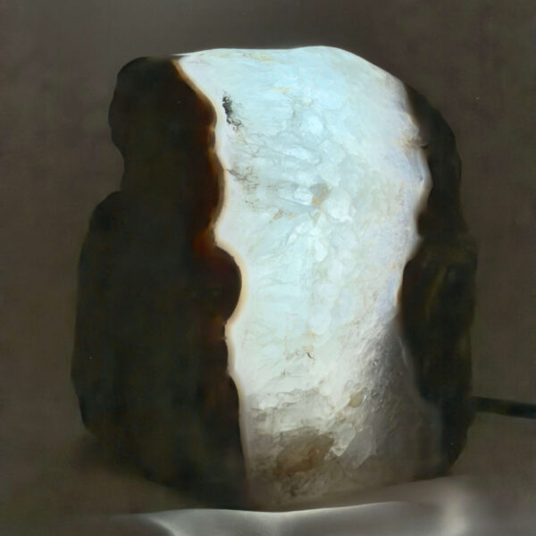 Agat lampe med naturlige mønstre og farvespil, der udsender et varmt og roligt lys i rummet.
