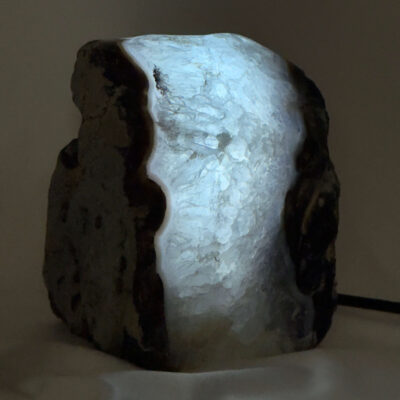 Agat lampe med naturlige mønstre og farvespil, der udsender et varmt og roligt lys i rummet.