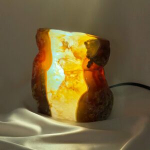 Agat lampe med naturlige bånd og farvespil, der udsender et varmt og roligt lys i rummet.