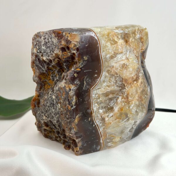 Agat lampe med naturlige bånd og farvespil, der udsender et varmt og roligt lys i rummet.