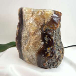 Agat lampe med naturlige bånd og farvespil, der udsender et varmt og roligt lys i rummet.