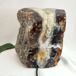 Agat lampe med naturlige bånd og farvespil, der udsender et varmt og roligt lys i rummet.