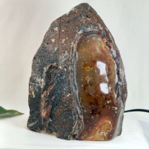 Agat lampe med naturlige bånd og farvespil, der udsender et varmt og roligt lys i rummet.