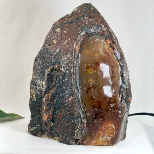 Agat lampe med naturlige bånd og farvespil, der udsender et varmt og roligt lys i rummet.