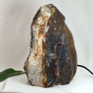 Agat lampe med naturlige bånd og farvespil, der udsender et varmt og roligt lys i rummet.